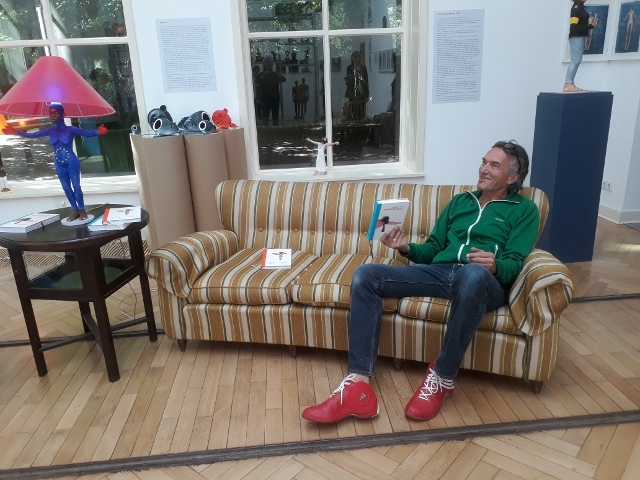 Volker März auf dem Sofa mit dem "Horizontalisten" in der Hand, Georg-Kolbe-Museum, 2018. Foto © Urszula Usakowska-Wolff